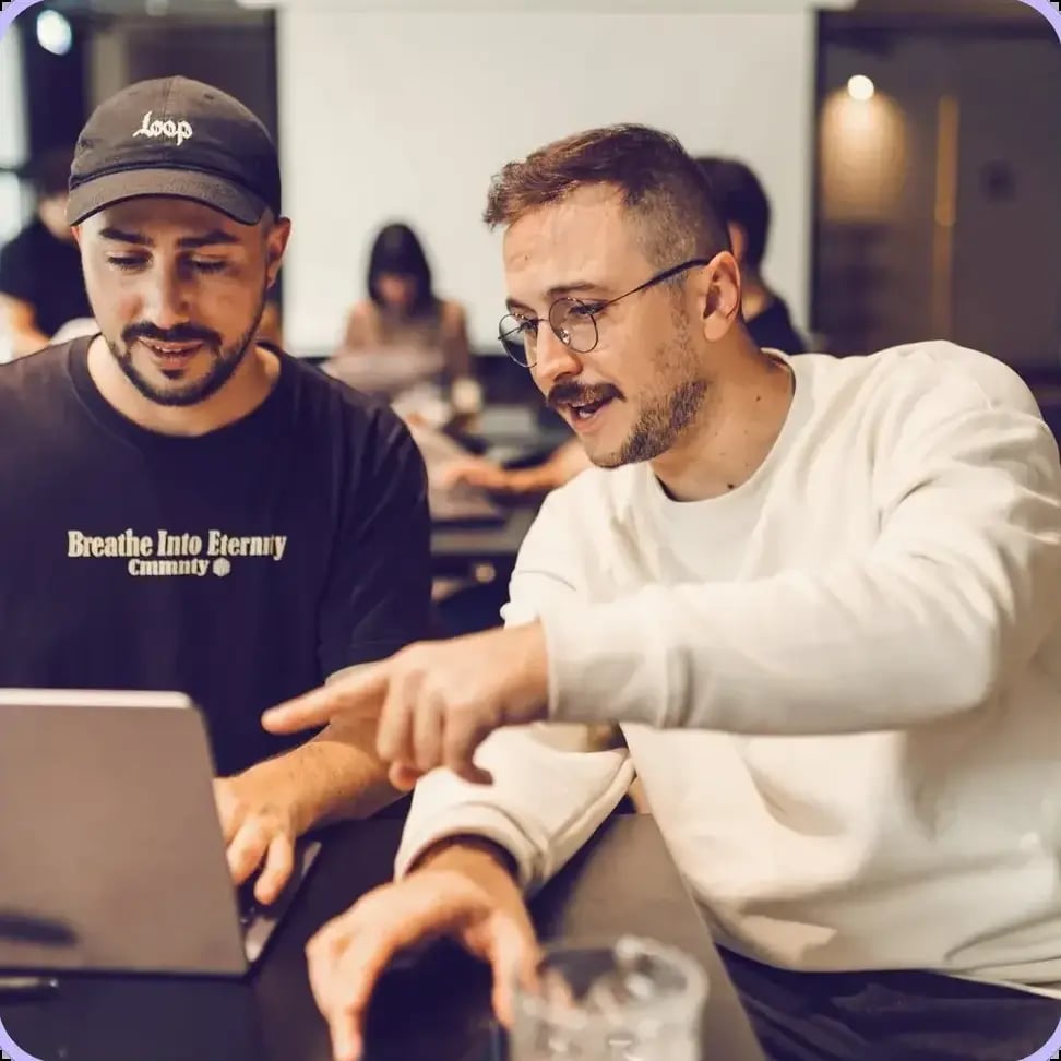 Deux collègues, dont un moustachu, travaillent ensemble au bureau