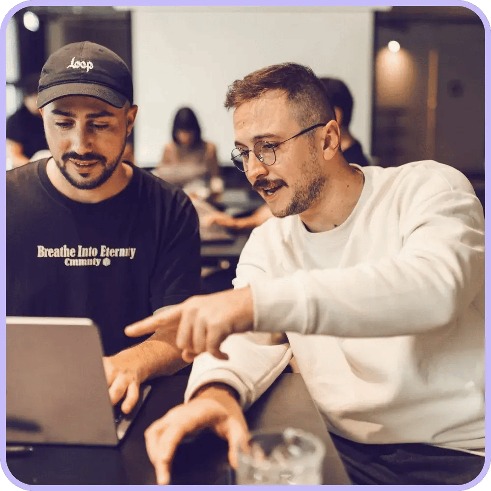 Two colleagues, one with a moustache, working together at the office