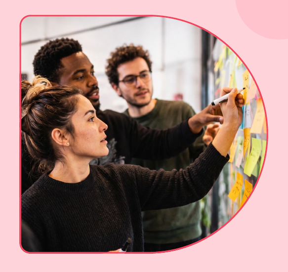 Driver 1 of workplace cohesion, build a shared direction: a team working in front of a wall of sticky notes