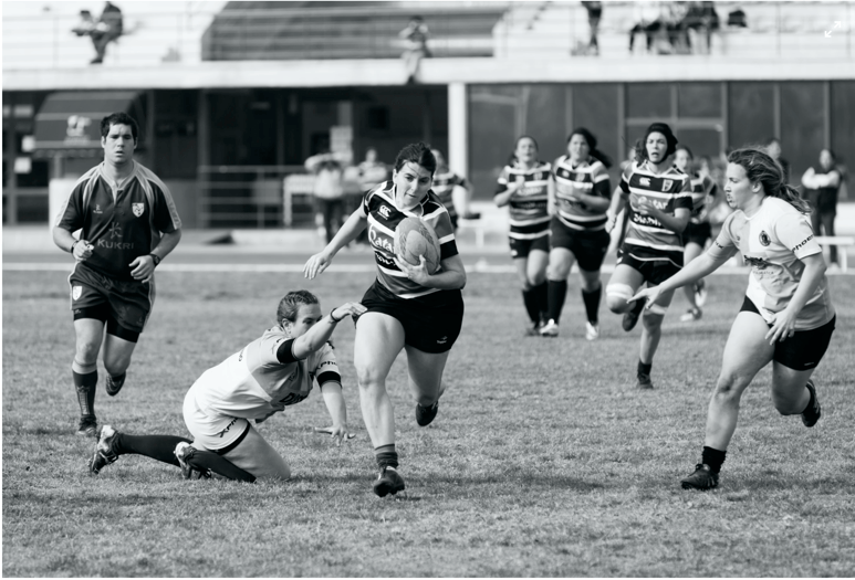 Equipe de rugbymen femmes et hommes unis sur le terrain / entrain de jouer au rugby